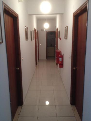 a long hallway with white walls and a tile floor at Dimitris Rooms in Vlikhon
