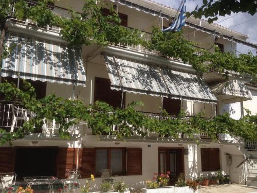 a building with a lot of windows and plants at Dimitris Rooms in Vlikhon