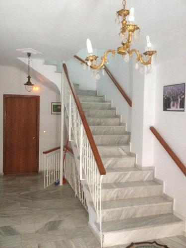 a staircase in a house with a chandelier at Dimitris Rooms in Vlikhon