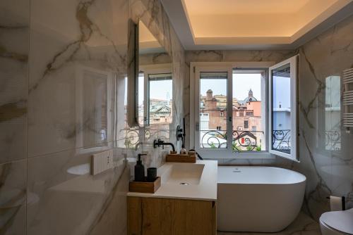baño con bañera, lavabo y ventana en PANORAMA APARTMENT en Bolonia