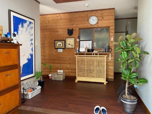 a room with a wooden wall with a clock at 遙かな亭 in Numazu