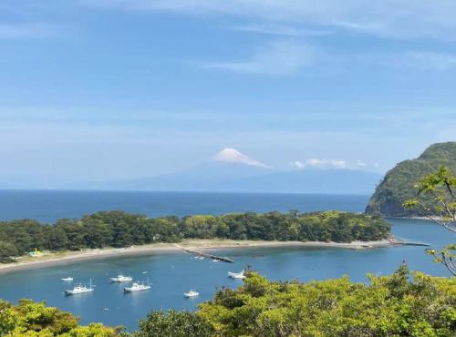 an island with boats in the water with a mountain in the background at 遙かな亭 in Numazu