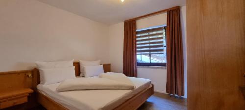 małą sypialnię z łóżkiem z oknem w obiekcie Ferienwohnung 3 Personen Alleinlage auf 1500m am Waldrand und Skigebiet Hochzeiger w mieście Jerzens