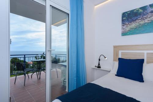 a bedroom with a bed and a balcony with the ocean at Habitacions Cau del Llop in Llança