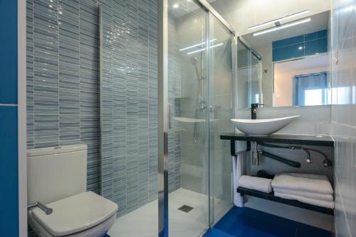 a bathroom with a toilet and a sink and a shower at Habitacions Cau del Llop in Llança