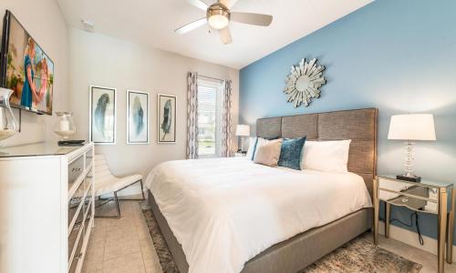 a bedroom with a large bed and a ceiling fan at Tillies Town in Orlando