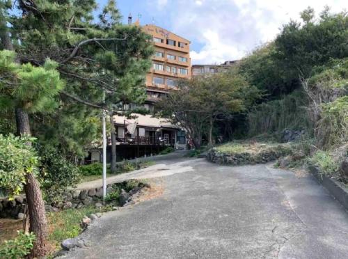 an empty road in front of a building at 遙かな亭 in Numazu
