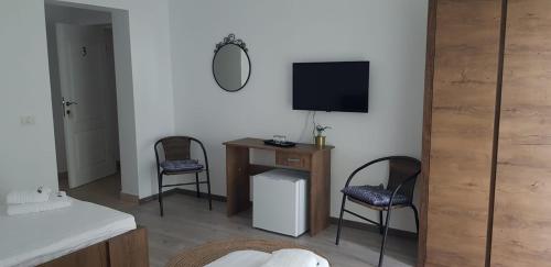 a living room with two chairs and a television at PENSIUNEA LA CUCI in Techirghiol