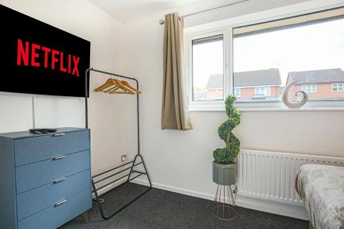 a bedroom with a blue dresser and a plant at Detached House - City Centre Location - Free Parking, Garden, Smart TVs with Netflix by Yoko Property in Milton Keynes