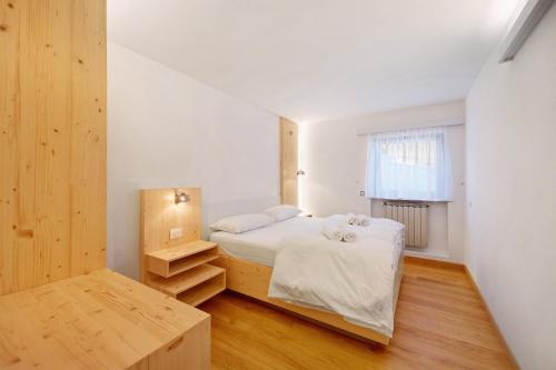 a bedroom with a white bed and a window at Roda A Parte in Vigo di Fassa