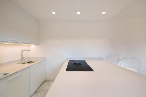 a white kitchen with a sink and a counter at Roda A Parte in Vigo di Fassa