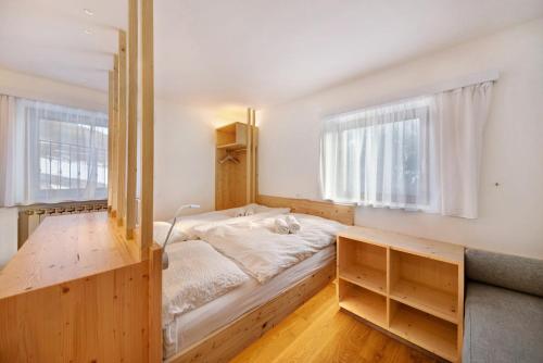 a bedroom with a bed and two windows at Roda A Parte in Vigo di Fassa