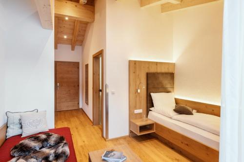 a small bedroom with a bed and a red rug at Dorfstube in Holzgau