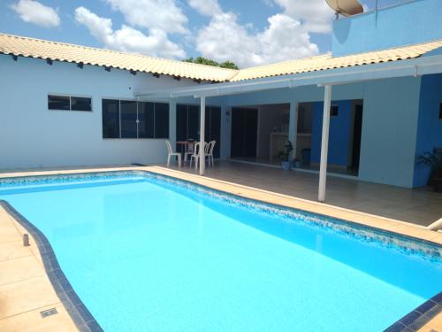 a swimming pool in front of a house at Casa azul in Barra do Garças
