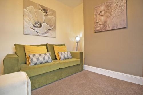 a living room with a couch and paintings on the wall at Cheerful two bedroom town house in Chester in Chester
