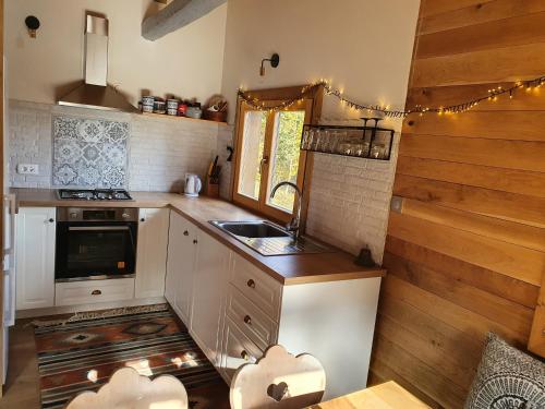 eine Küche mit weißen Schränken und einem Waschbecken in der Unterkunft Starry Laz mountain house in Ravna Gora