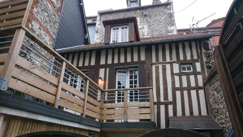 une maison avec une terrasse sur le côté dans l'établissement Honfleur effet mer 2, à Honfleur