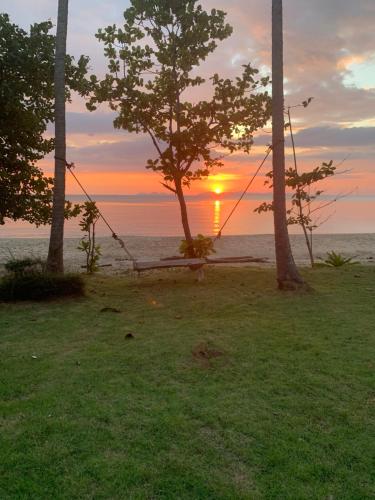 Sun Smile Beach Koh Jum في كو جوم: أرجوحة أمام المحيط مع غروب الشمس