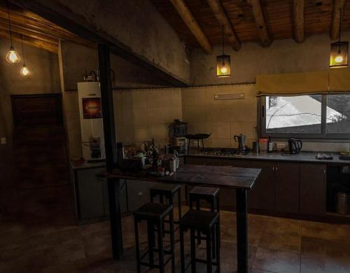 una cocina con mesa y taburetes. en Estrella del Valle - Mendoza en Mendoza