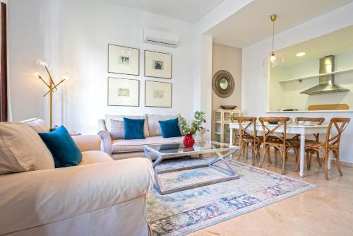 a living room with a couch and a table at Genteel Home Arfe Terrace in Seville