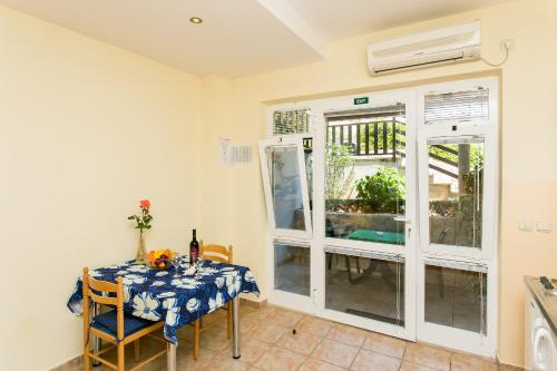 a dining room with a table and chairs and a window at Apartments Radić in Dubrovnik