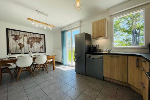 uma cozinha com uma mesa e um frigorífico em New house in the heart of a hamlet near Amboise and Chenonceaux em Athée-sur-Cher