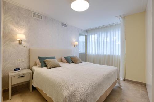 ein Schlafzimmer mit großem Bett und Fenster in der Unterkunft Luxury 3 Bedroom Beach Front Apartment in Marbella in Marbella
