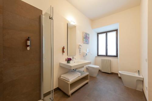 a bathroom with a sink and a toilet and a shower at Hotel La Corte in Cascia