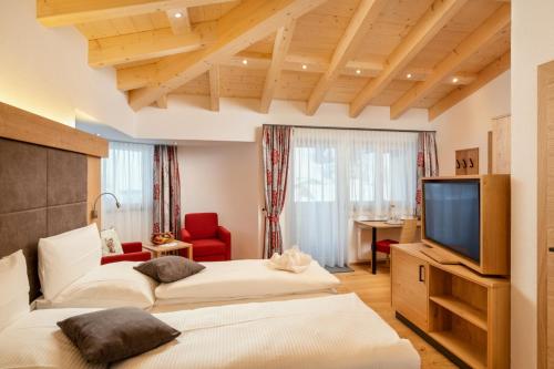 a hotel room with two beds and a television at Dorfstube in Holzgau