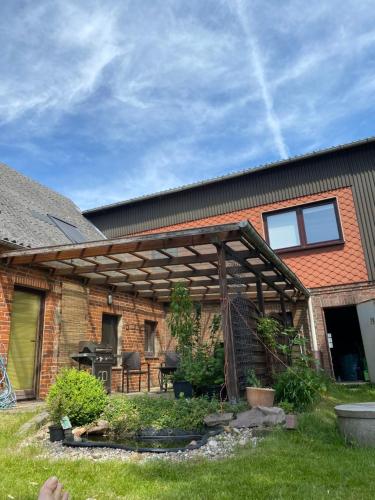 a wooden pergola in the backyard of a house at De lütte Moehl in Hollingstedt