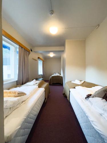 eine Reihe von Betten in einem Hotelzimmer in der Unterkunft Hotell Nesbyen in Nes i Ådal