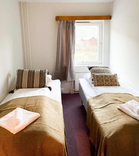 2 camas en una habitación con ventana en Hotell Nesbyen, en Nes i Ådal