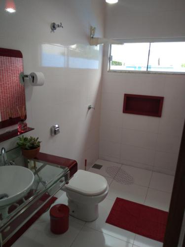 a bathroom with a toilet and a shower and a sink at Casa azul in Barra do Garças