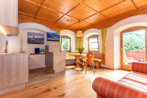 a kitchen and living room with a wooden ceiling at Reitanlage Dagnhof in Walchsee