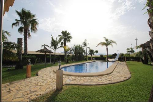 uma piscina num parque com palmeiras em Casa Rural EL CAMPICO em Puerto de Mazarrón