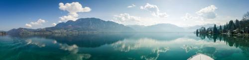 a boat on a lake with mountains in the background at Hotel Stadler am Attersee in Unterach am Attersee