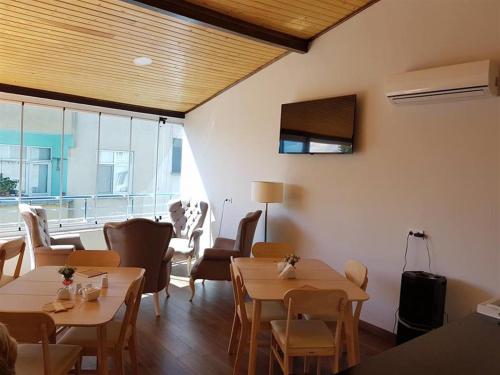 錫諾普的住宿－Harbour Hotel，餐厅设有桌椅和大窗户。