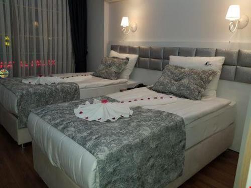 Habitación de hotel con 2 camas y sofá en Harbour Hotel en Sinope