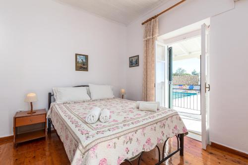 een slaapkamer met een bed met een tafel en een raam bij Villa Georgina in Nisakion
