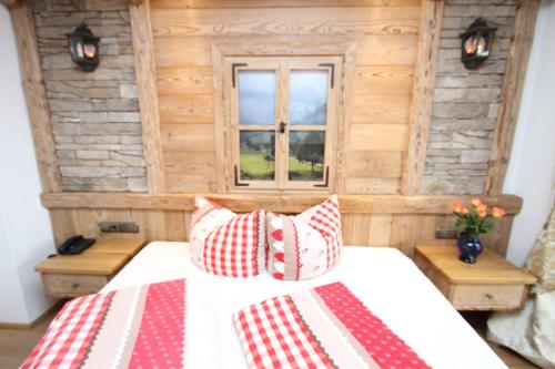 a bedroom with a bed with red and white pillows at Reitanlage Dagnhof in Walchsee