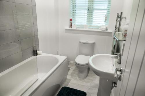 uma casa de banho com uma banheira, um WC e um lavatório. em Sutton House em Sutton in Ashfield