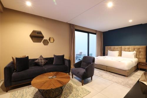 um quarto com uma cama, um sofá e uma mesa em Address Hotel Casablanca em Casablanca