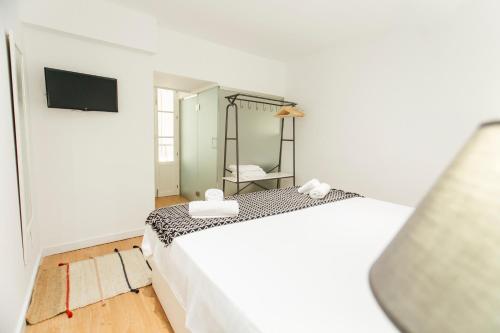 een slaapkamer met een wit bed en een spiegel bij CSE Pajaritos in Sevilla