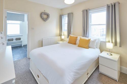 a bedroom with a large white bed with yellow pillows at Host & Stay - The Townhouse in Scarborough