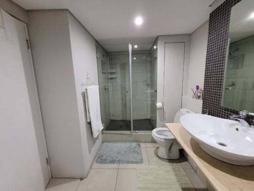 a bathroom with a sink and a toilet and a shower at Accommodation Front - Exquisite 6 Sleeper Apartment with Ocean Views in Durban