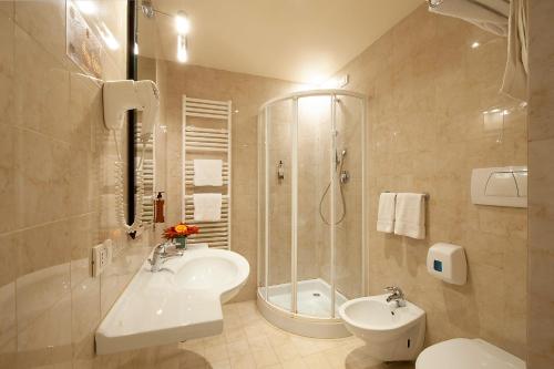 a bathroom with a sink and a shower and a toilet at La Reggia Sporting Center Hotel in Cascia