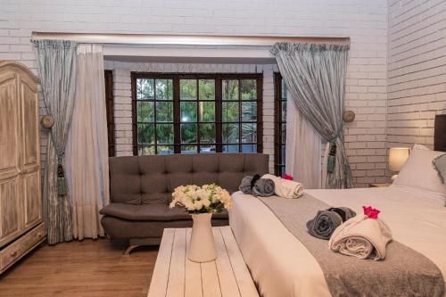 um quarto com 2 camas e um sofá em Mereke Manor em Centurion