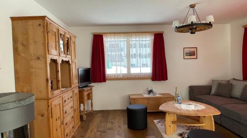 een woonkamer met een bank en een tafel bij Ferienwohnung mit idyllischer Aussicht in Klosters
