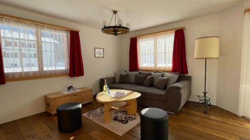 a living room with a couch and a table at Ferienwohnung mit idyllischer Aussicht in Klosters