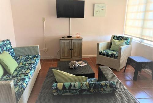 - un salon avec deux canapés et une télévision dans l'établissement Luquillo Sunrise Beach Inn, à Luquillo